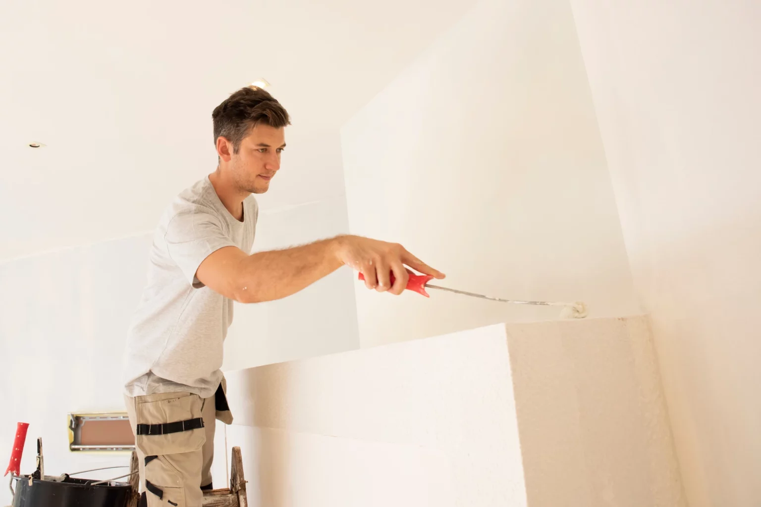 Photo d'un peintre en bâtiment qui travaille.